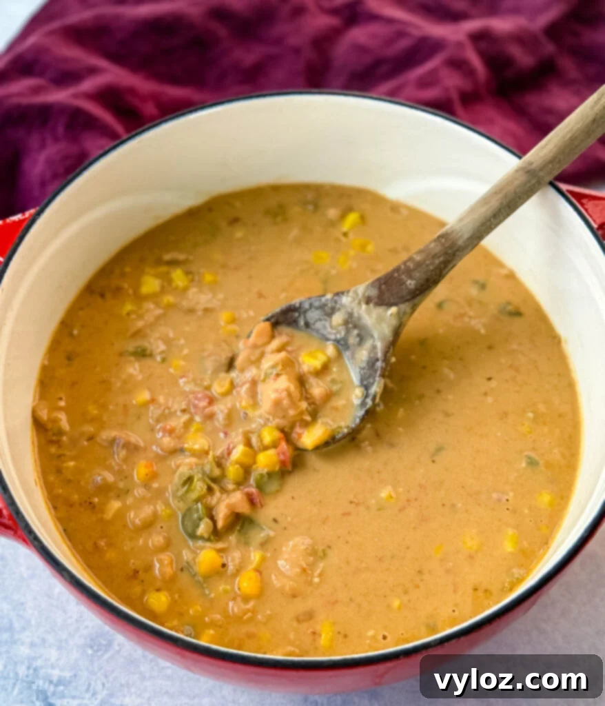A rich, creamy white chicken chili presented in a vibrant red Dutch oven, showcasing its inviting color and texture.