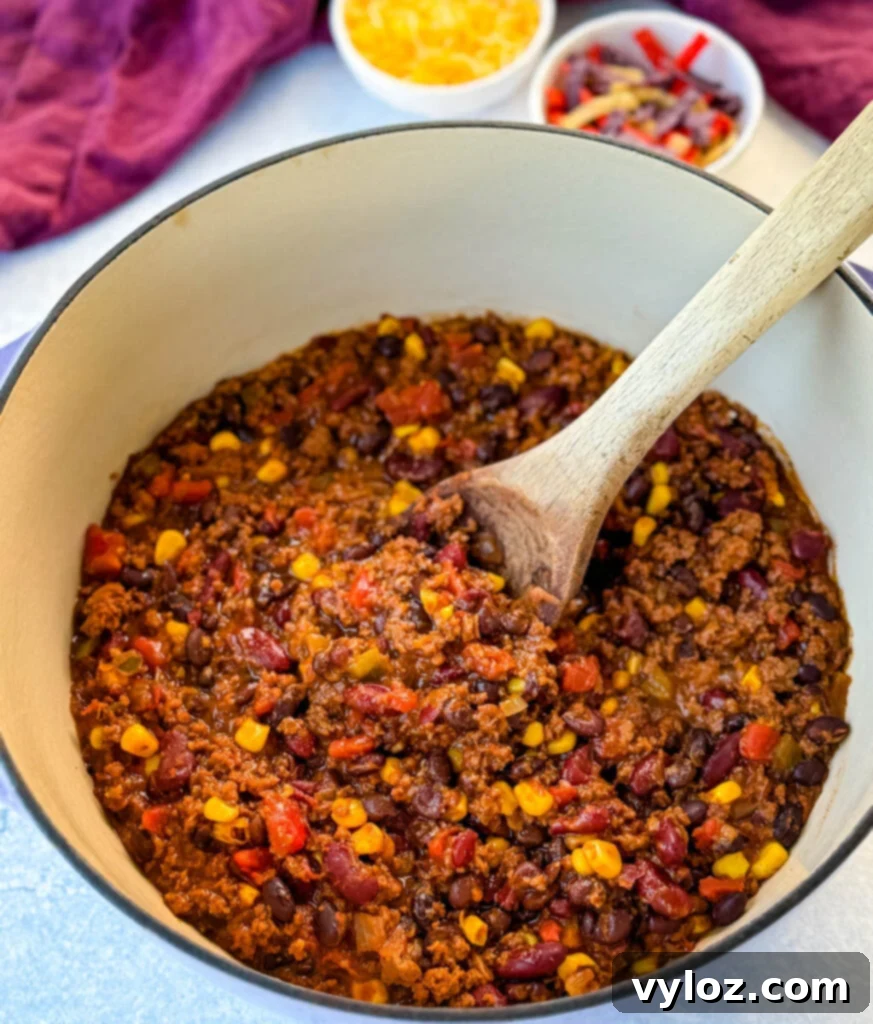 Taco Chili 6 beef taco chili in a Dutch oven with a wooden spoon