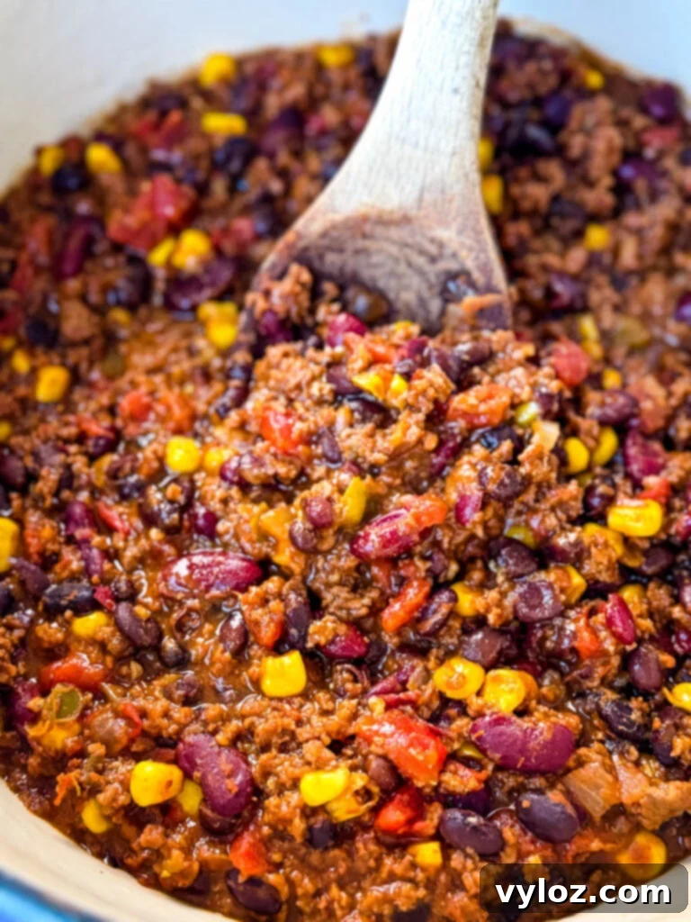 Taco Chili 7 beef taco chili in a Dutch oven with a wooden spoon