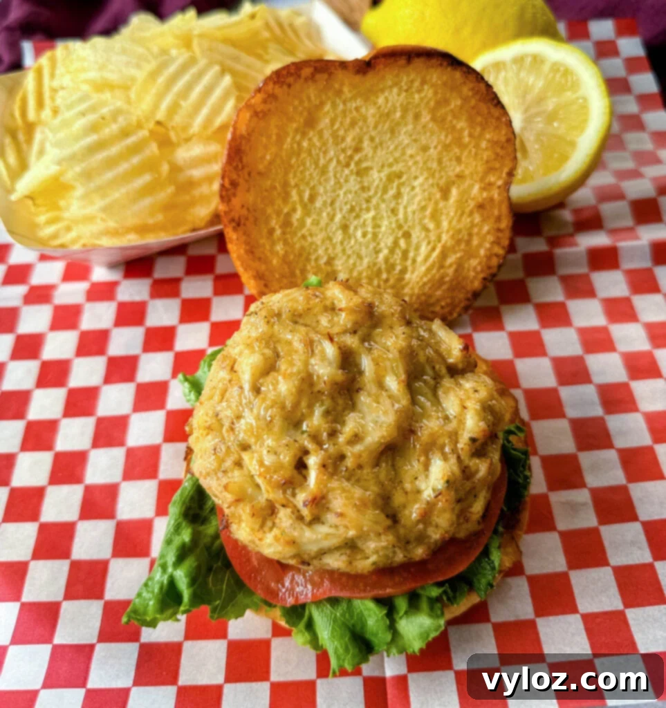 crab cake sandwich on a brioche bun with lettuce tomatoes and a side of chips