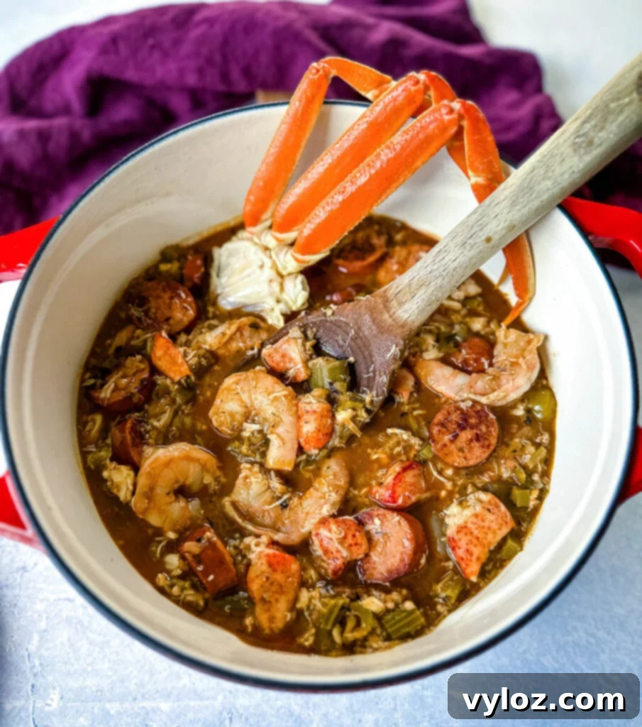 A large Dutch oven filled with rich Cajun seafood gumbo, featuring plump shrimp, succulent crab meat, and crab legs, served alongside white rice with a wooden spoon for serving.