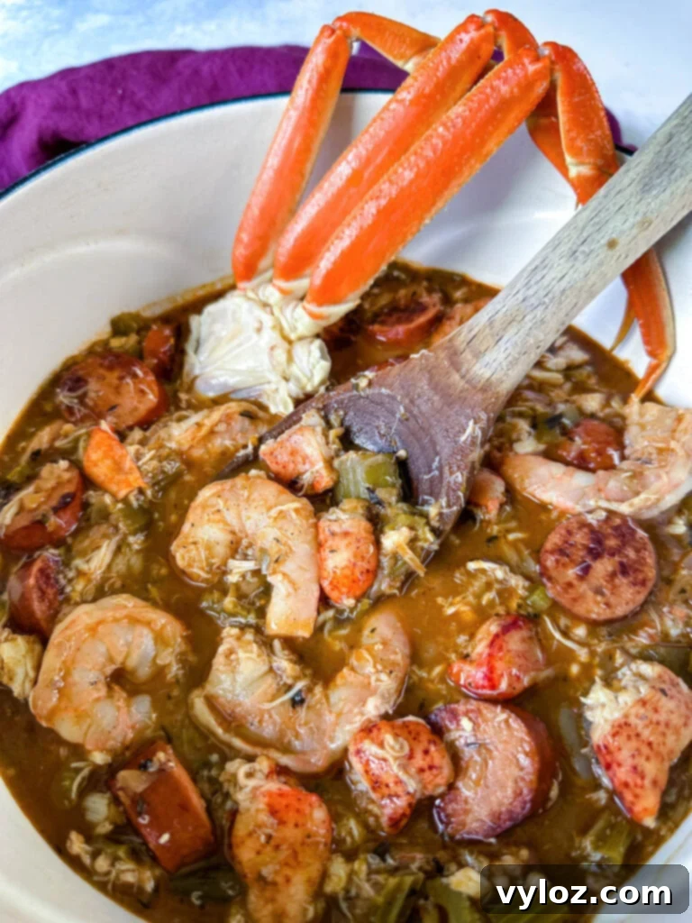 A close-up shot of a rich Cajun seafood gumbo with plump shrimp, succulent crab meat, and crab legs, served alongside white rice in a large Dutch oven with a wooden spoon for serving.