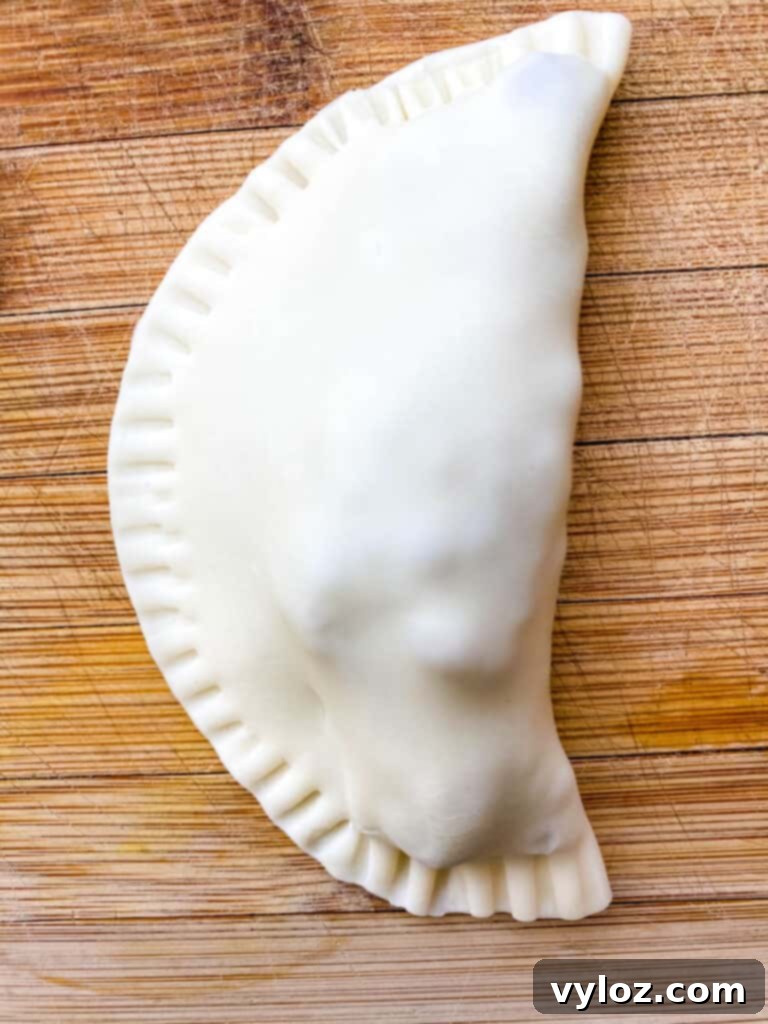 Golden Air Fryer Dessert Empanadas 12 uncooked beef empanada on a bamboo cutting board