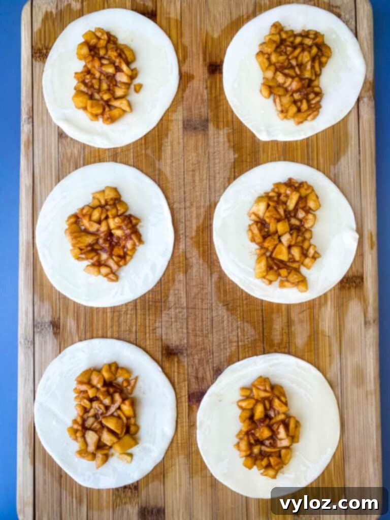 Golden Air Fryer Dessert Empanadas 10 empanadas on a cutting board with apple filling