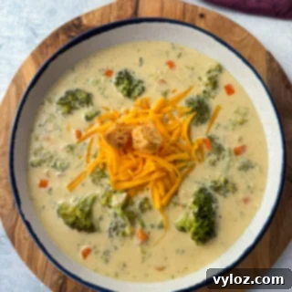 Velvety Broccoli Cheddar Soup 11 broccoli cheddar soup in a white bowl with grated cheddar cheese and croutons
