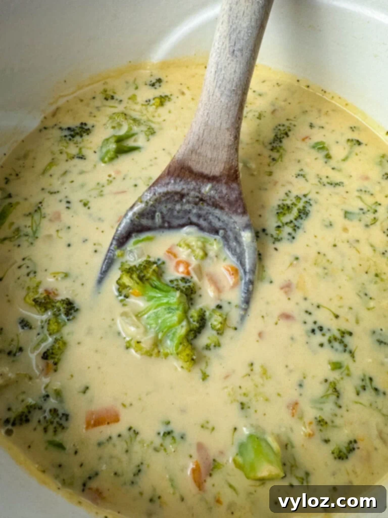 Velvety Broccoli Cheddar Soup 7 broccoli cheddar soup in a Dutch oven with a wooden spoon