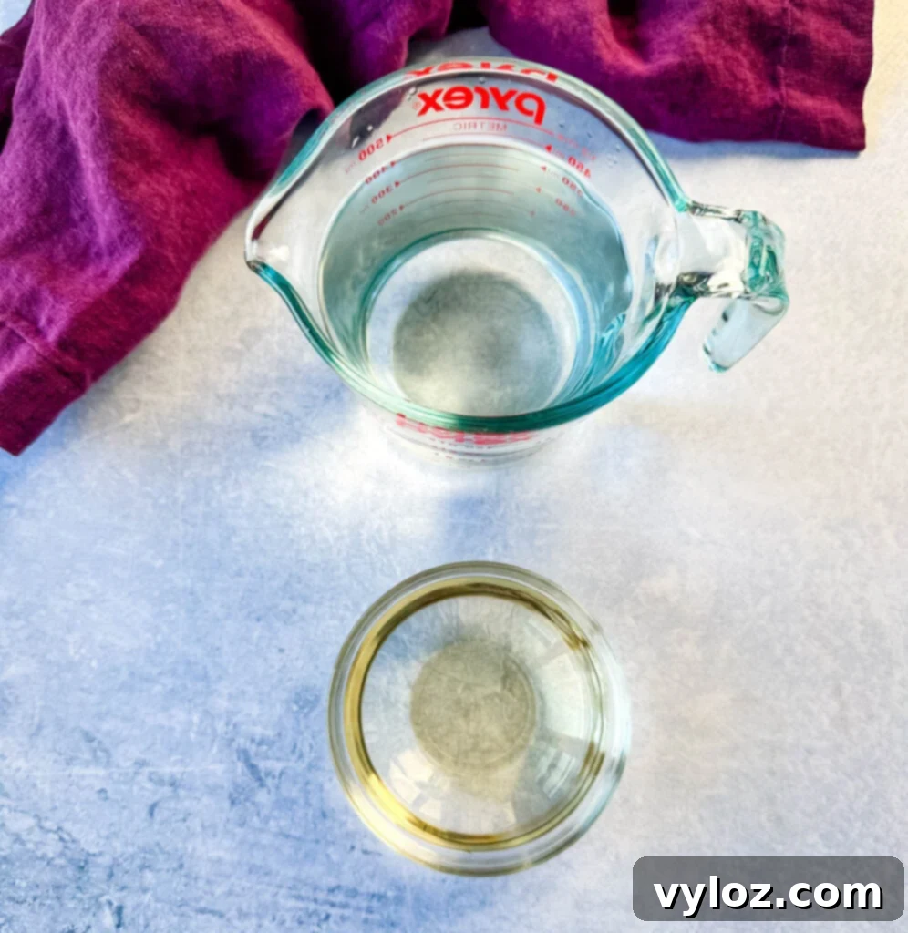 Oceanic Flavor Base 4 A glass of water and a glass of dry white wine side-by-side, ingredients for enhancing seafood stock.