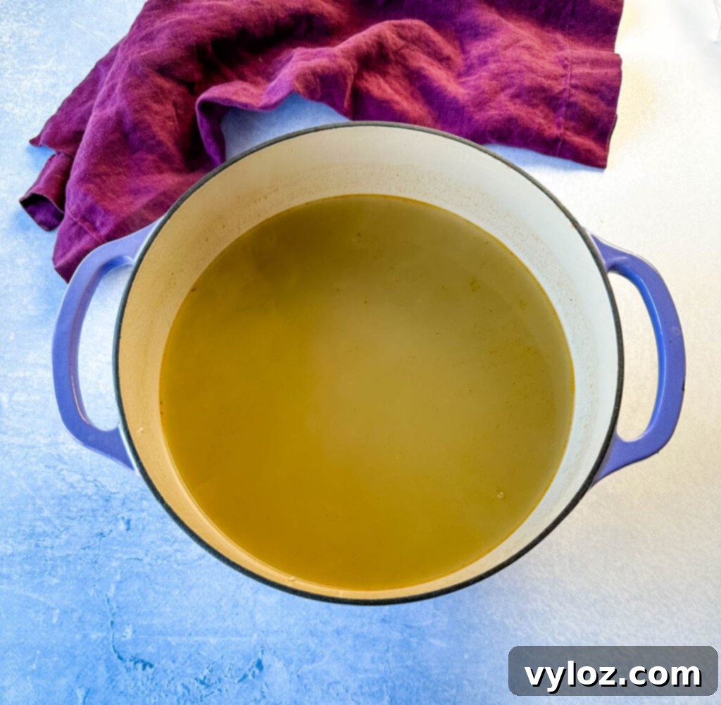 Oceanic Flavor Base 8 Clear, golden homemade seafood stock fills a Dutch oven, ready to be used as a flavorful base.