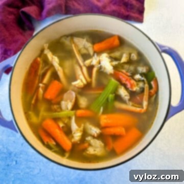 Oceanic Flavor Base 10 Homemade seafood stock with crab shells, carrots, and celery in a Dutch oven, ready to be used in various recipes.