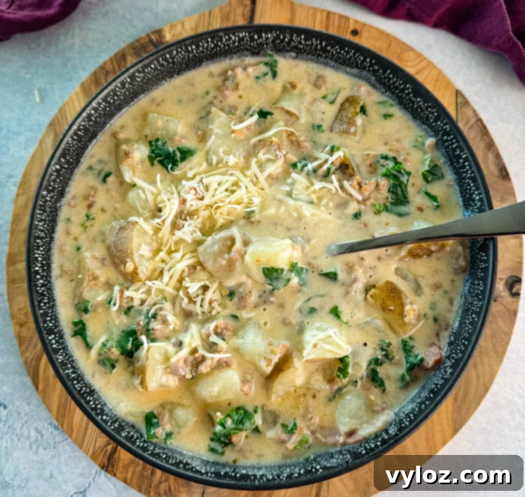 Hearty Italian Sausage and Kale Soup 2 Italian sausage soup with potatoes and kale in a black bowl with grated parmesan cheese