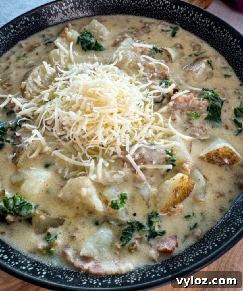 Hearty Italian Sausage and Kale Soup 9 Italian sausage soup with potatoes and kale in a black bowl with grated parmesan cheese