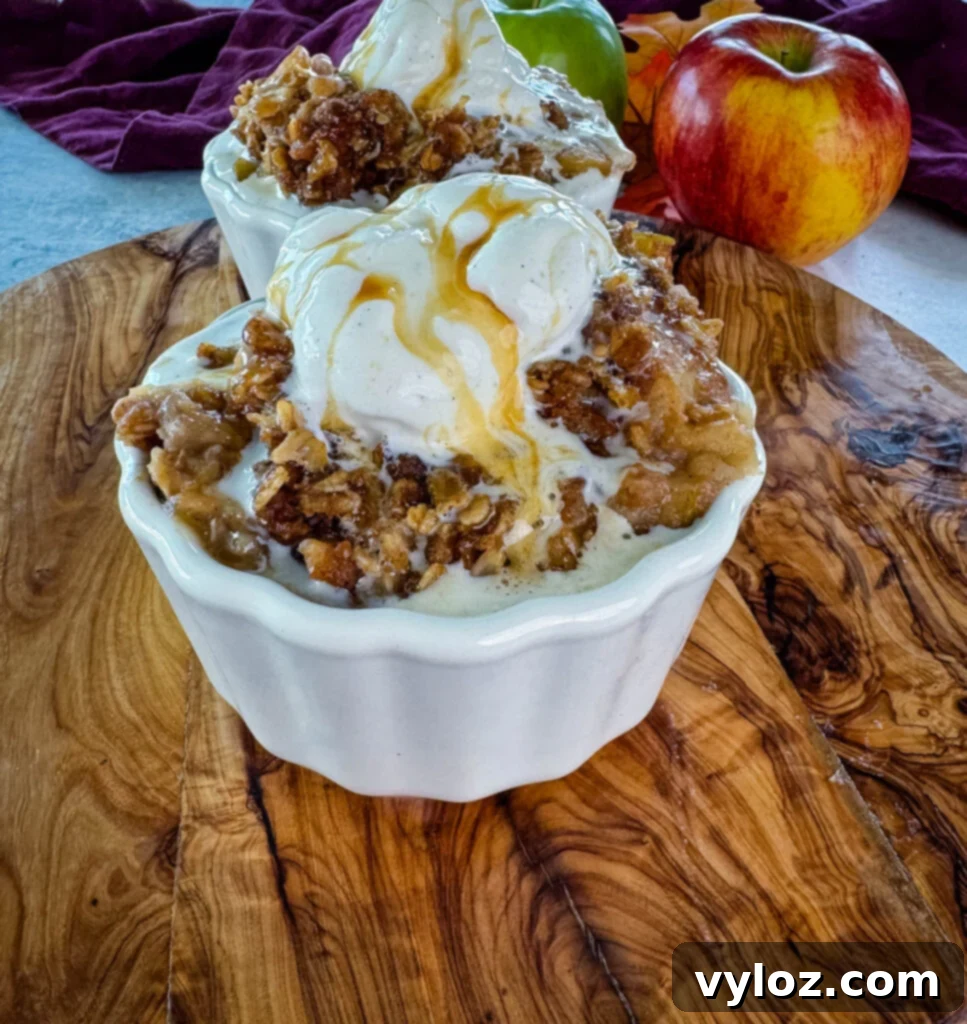 Effortless Crockpot Apple Crumble 11 slow cooker Crockpot apple crisp in a white bowl with a scoop of vanilla ice cream and caramel