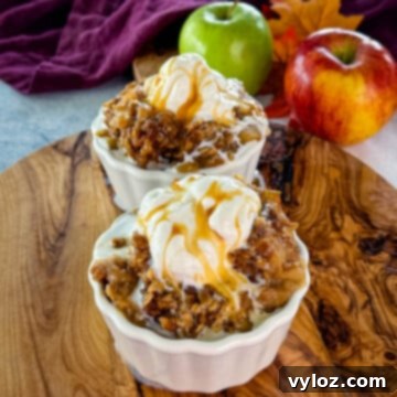 Effortless Crockpot Apple Crumble 13 slow cooker Crockpot apple crisp in a white bowl with a scoop of vanilla ice cream and caramel