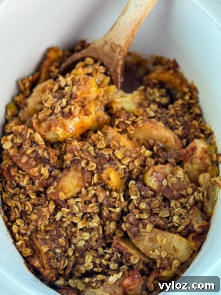 Effortless Crockpot Apple Crumble 8 apple crisp in a white Crockpot slow cooker