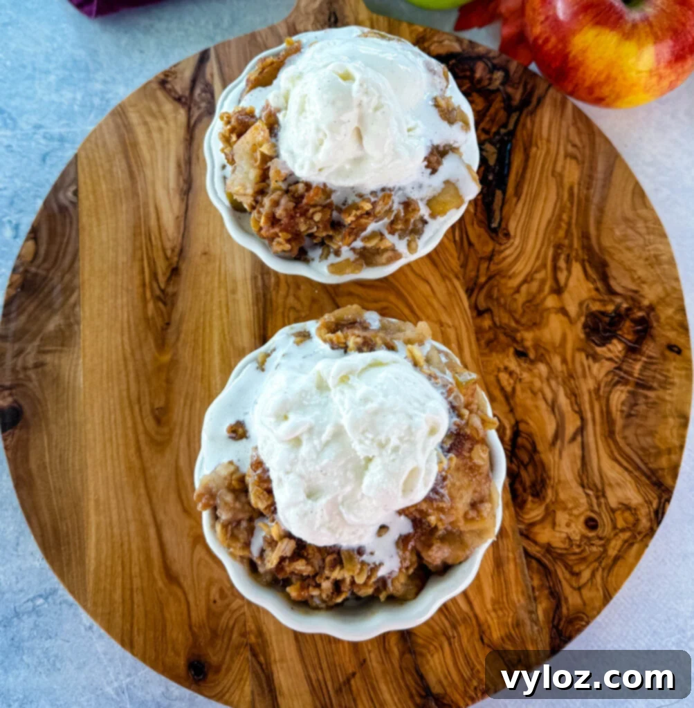 Effortless Crockpot Apple Crumble 9 slow cooker Crockpot apple crisp in a white bowl with a scoop of vanilla ice cream