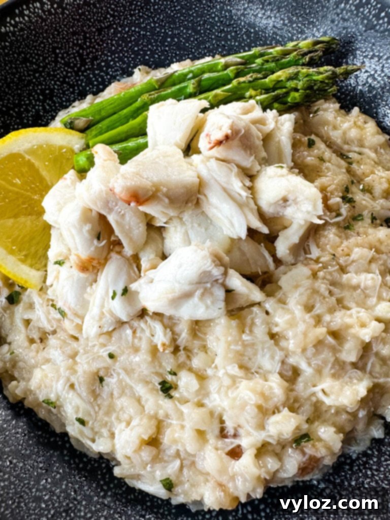 crab risotto in a black bowl with fresh lemon and asparagus