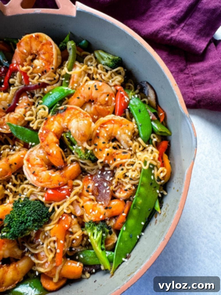 shrimp stir fry with noodles, vegetables, and a homemade sauce in a skillet