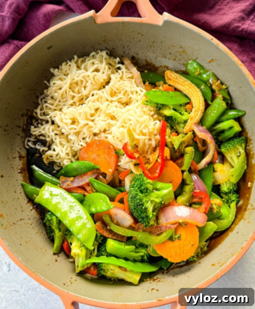 shrimp stir fry with noodles, vegetables, and a homemade sauce in a skillet