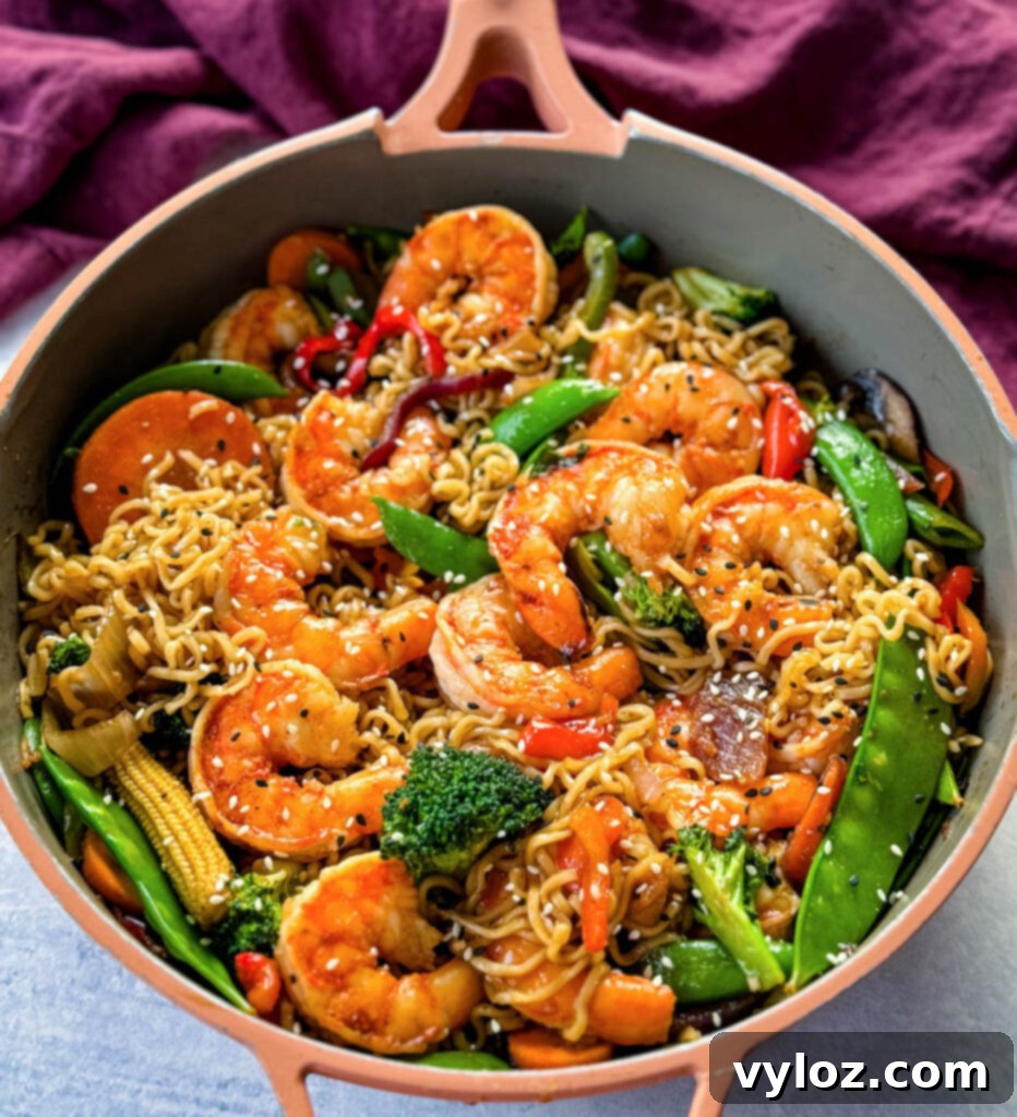 shrimp stir fry with noodles, vegetables, and a homemade sauce in a skillet