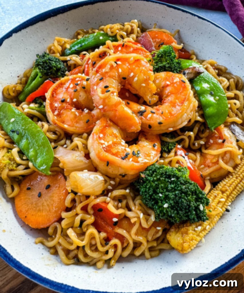shrimp stir fry with noodles, vegetables, and a homemade sauce in a white bowl