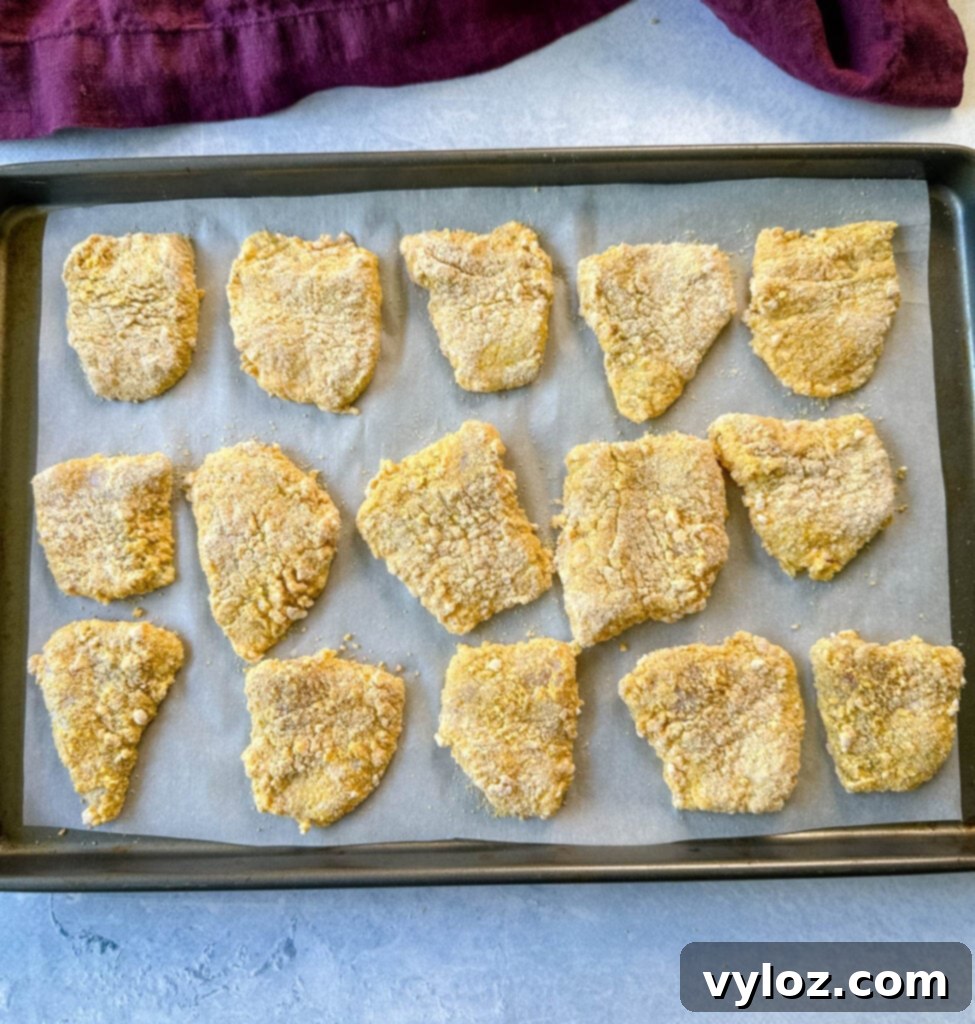 Crispy Fish Fry Mix 6 Crispy breaded catfish nuggets cooling on a sheet pan lined with parchment paper.
