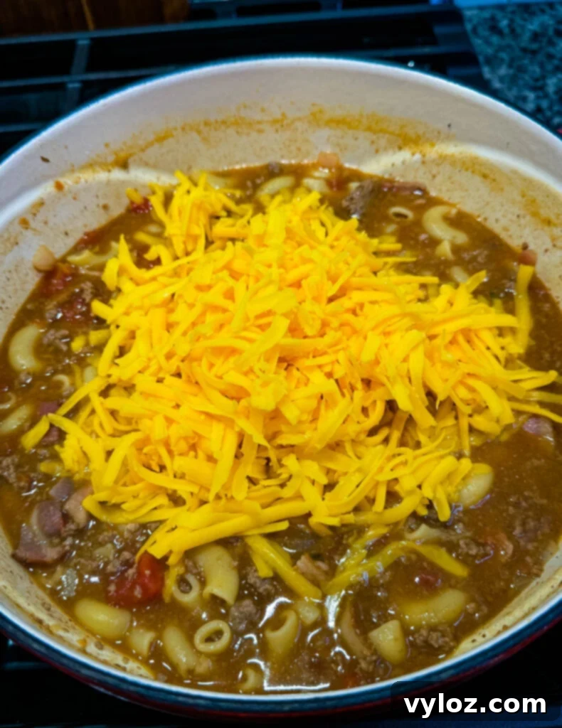 Savory Bacon Cheeseburger Mac Soup 7 bacon cheeseburger soup with fresh grated cheese in a Dutch oven