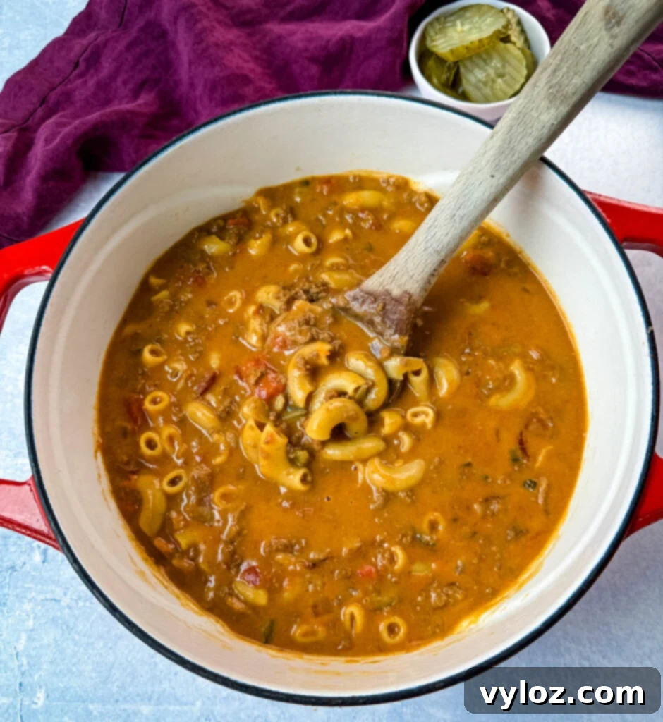 Savory Bacon Cheeseburger Mac Soup 8 bacon cheeseburger soup with a wooden spoon in a Dutch oven