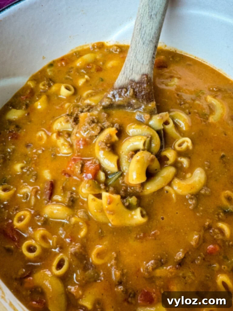 Savory Bacon Cheeseburger Mac Soup 9 bacon cheeseburger soup with a wooden spoon in a Dutch oven