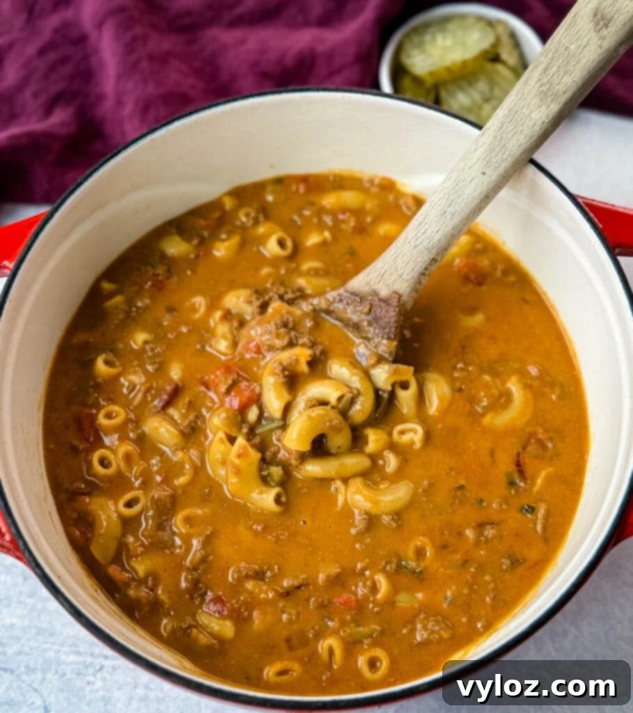 Savory Bacon Cheeseburger Mac Soup 10 bacon cheeseburger soup with a wooden spoon in a Dutch oven