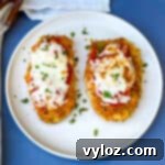 Air Fryer Panko Breaded Chicken Parmesan with Marinara Sauce on a white plate