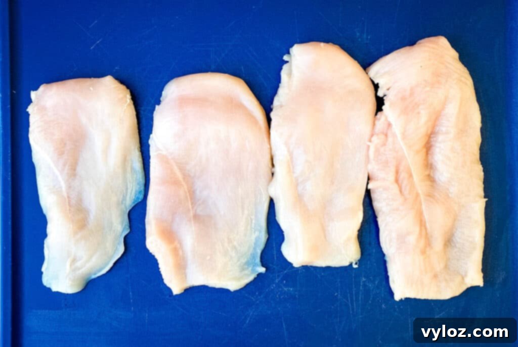 raw chicken breasts on a blue cutting board