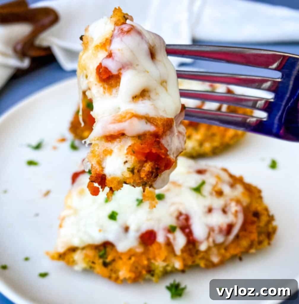 person holding a fork full of air fryer chicken parmesan