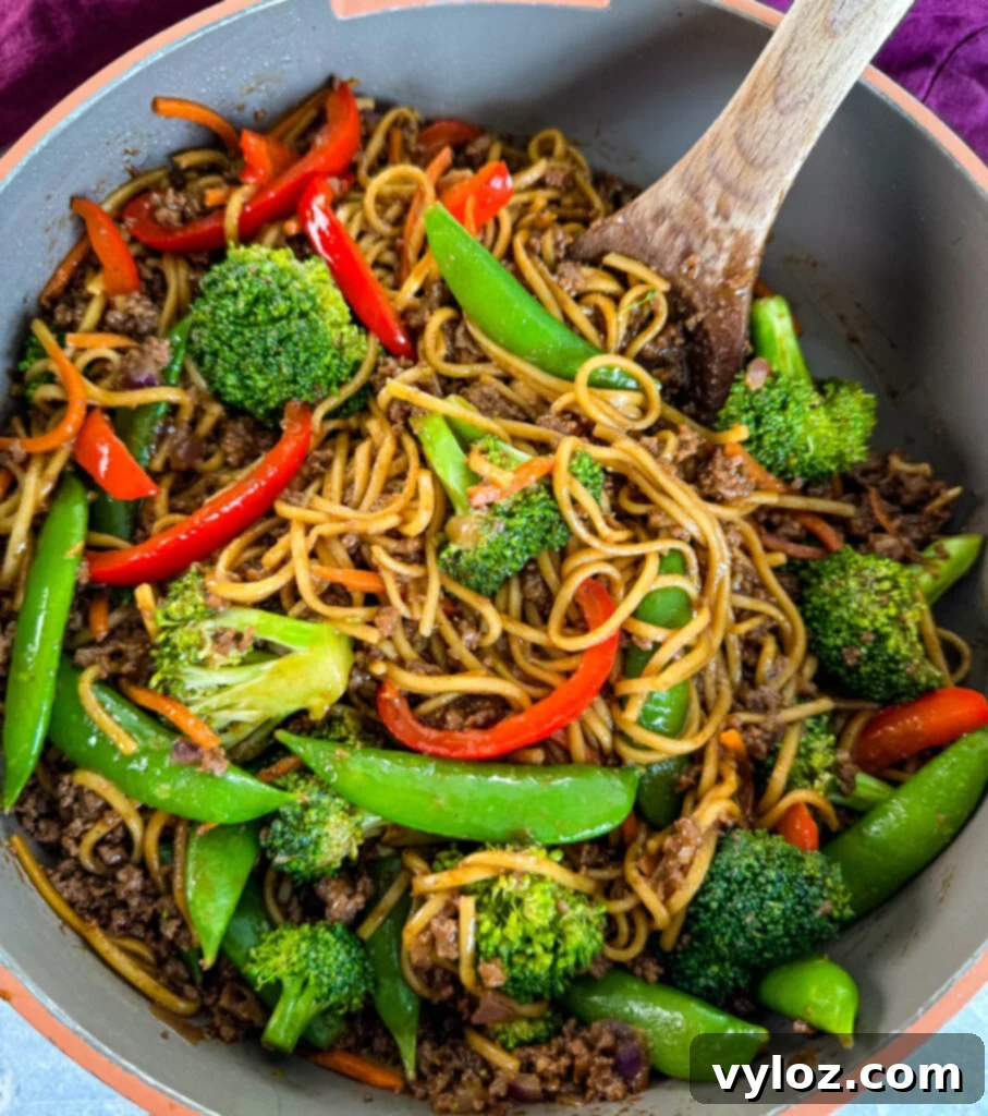 Flavorful Homemade Ground Beef Lo Mein 6 Ground beef lo mein and vegetables being mixed in a skillet with a wooden spoon