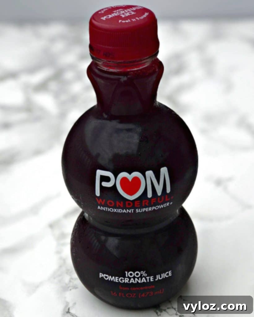 Ruby Red Holiday Fizz 3 Two sparkling Pomegranate Holiday Mimosas, garnished with fresh pomegranate seeds, beautifully arranged on a festive table.