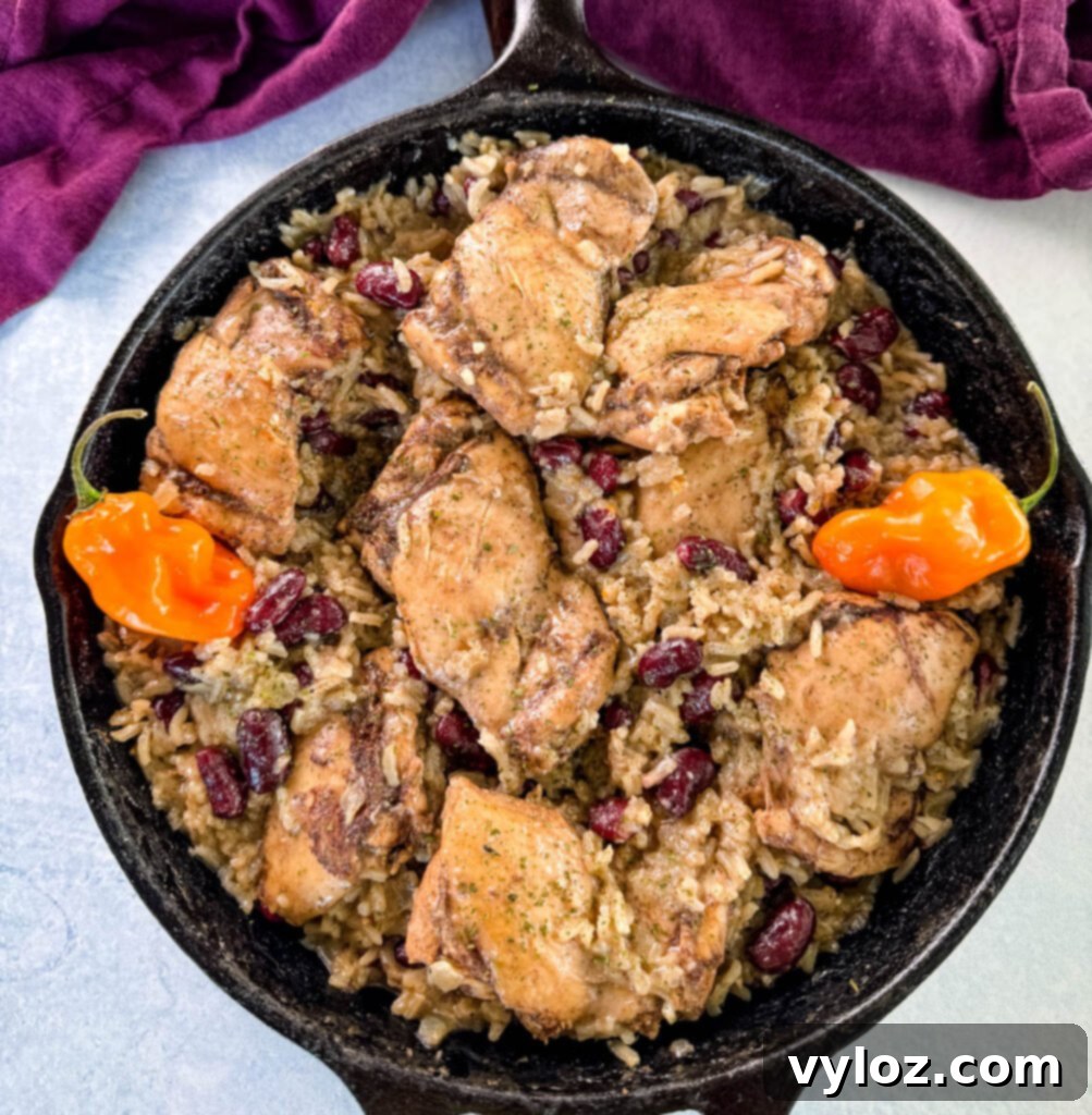 jerk chicken, rice, peas, red beans, and peppers in a cast iron skillet