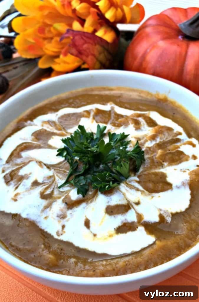A rustic presentation of Instant Pot Pumpkin Spice and Sweet Potato Soup with bread and autumn leaves