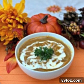 Instant Pot Pumpkin Spice and Sweet Potato Soup in a white bowl with fall decor in the background