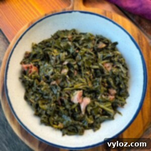 collard greens and ham hocks in a white bowl
