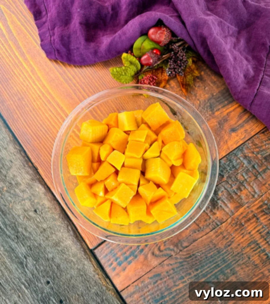 Diced chunks of butternut squash in a clear glass bowl, ready for cooking