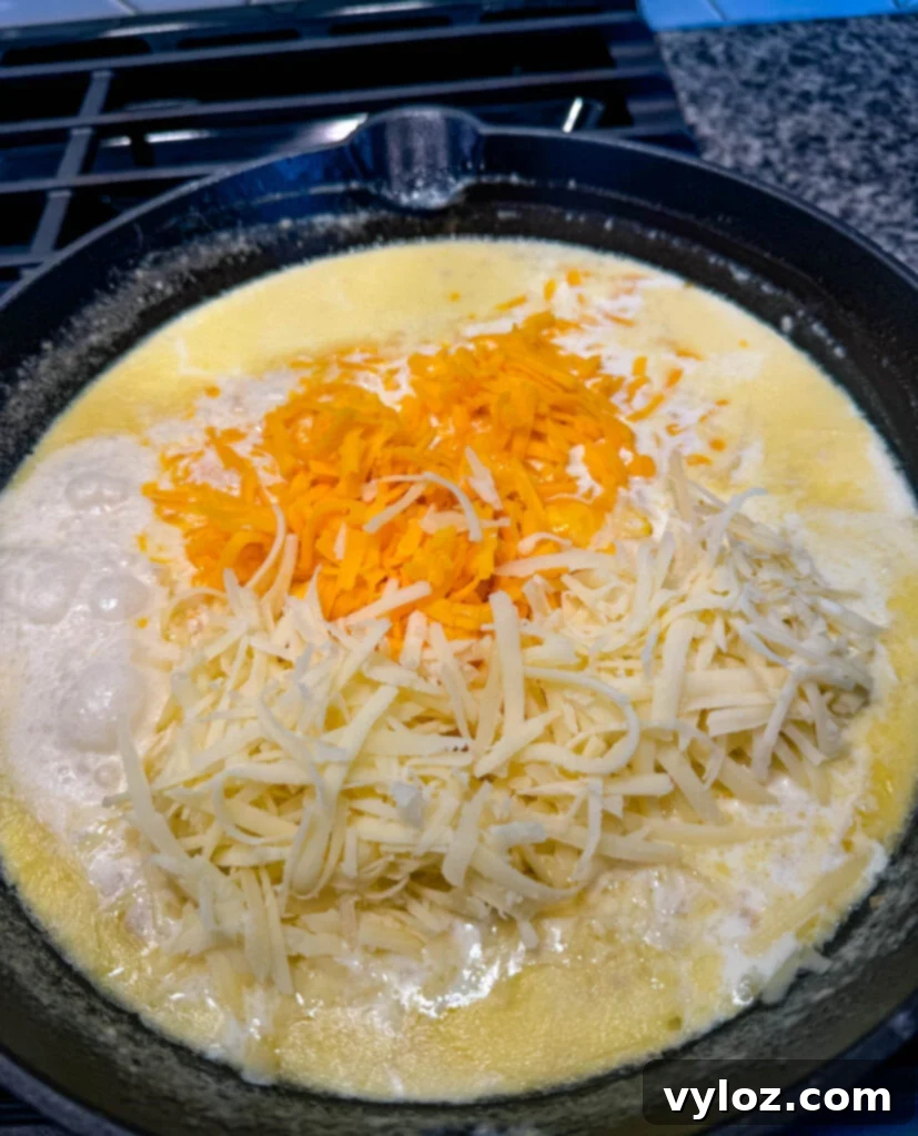Close-up of a perfectly cooked roux bubbling gently in a cast iron skillet, ready for cheese, setting the stage for creamy mac and cheese