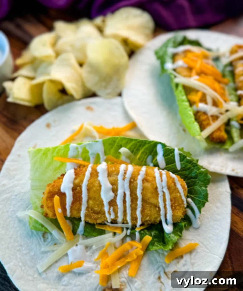 Homemade Chicken Snack Wraps 11 A perfectly rolled chicken snack wrap on a tortilla with ranch dressing and shredded cheese, ready for enjoyment.