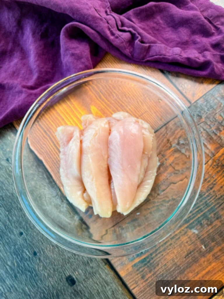 Homemade Chicken Snack Wraps 4 Raw chicken tenderloins in a glass bowl, ready for preparation.