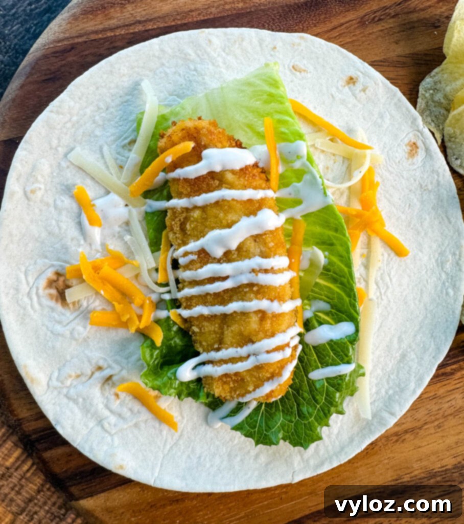 Homemade Chicken Snack Wraps 9 A fully assembled chicken snack wrap showcasing tender chicken, ranch dressing, and shredded cheese, ready to be eaten.