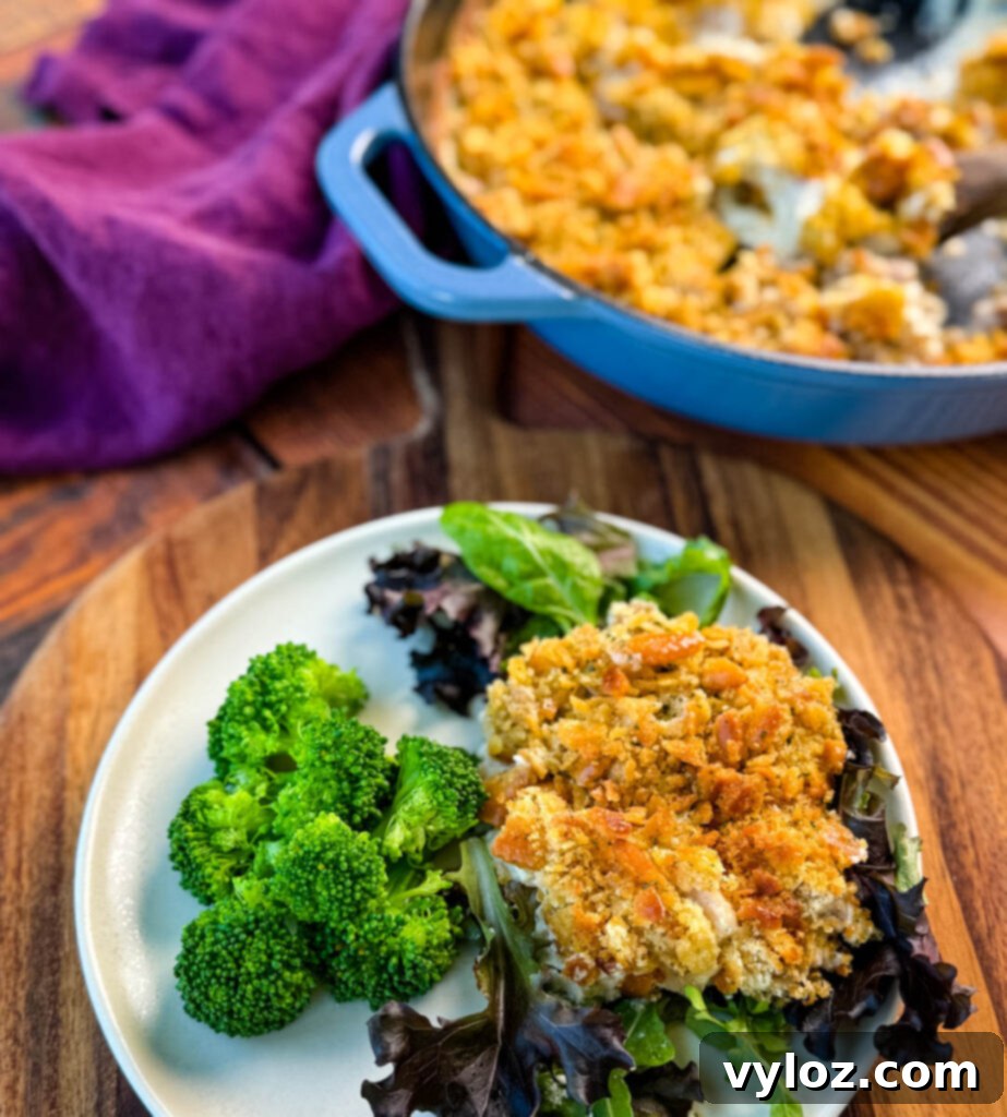 Million Dollar Chicken Bake 9 million dollar chicken casserole on a plate with mixed greens and broccoli