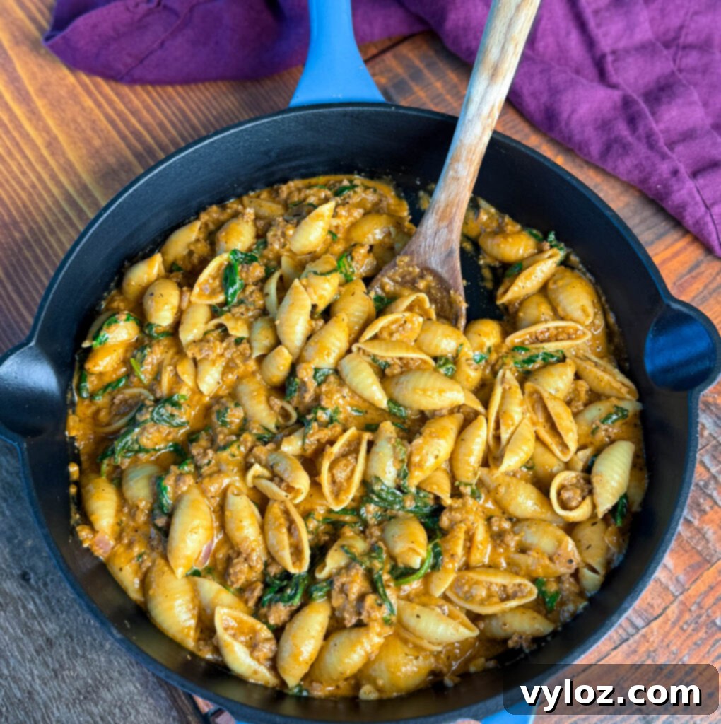high protein beef and shells pasta with spinach in a cast iron skillet