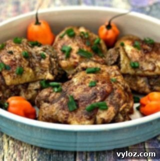 Flavorful Instant Pot Jamaican Jerk Chicken Thighs 9 Jamaican jerk chicken thighs on a serving platter garnished with green onions and habanero peppers