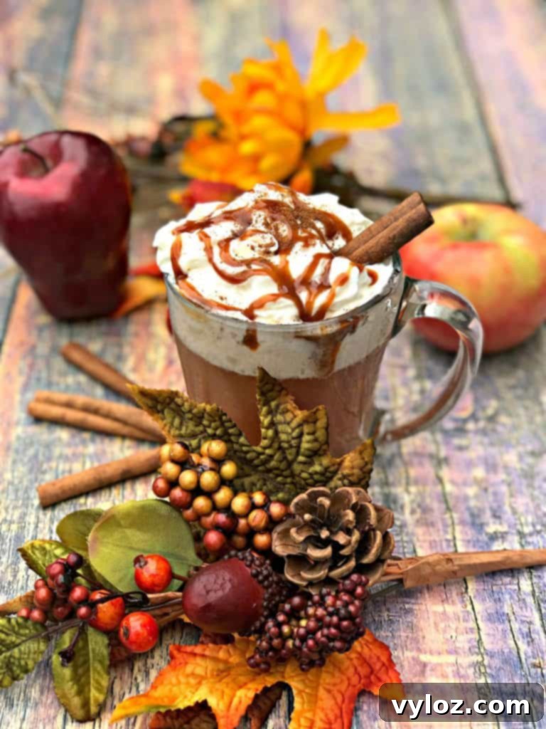Homemade Skinny Copycat Starbucks Caramel Apple Cider in a mug, surrounded by autumn decor.