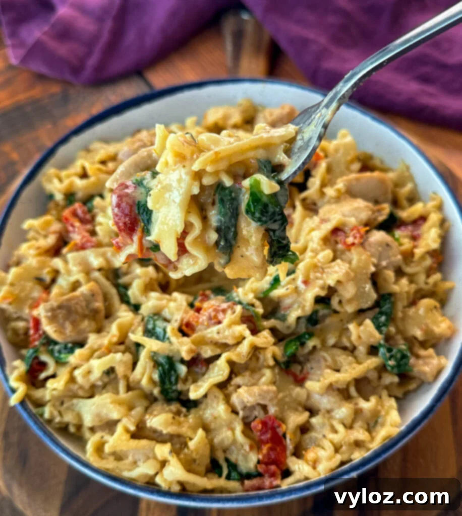 Proposal-Perfect Chicken Pasta 2 fork full of marry me chicken pasta with sundried tomatoes, parmesan, and spinach