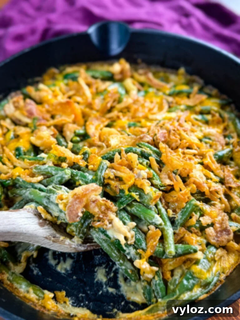 Creamy Green Bean Delight 2 green bean casserole without canned cream of mushroom soup in a skillet with a wooden spoon