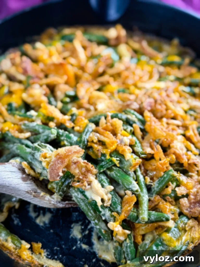 Creamy Green Bean Delight 14 green bean casserole without canned cream of mushroom soup in a skillet with a wooden spoon